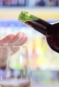 Womans hand rejecting more alcohol from wine bottle in bar