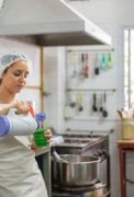 Vrouw met thermos in grootkeuken.