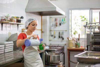 Vrouw met thermos in grootkeuken.